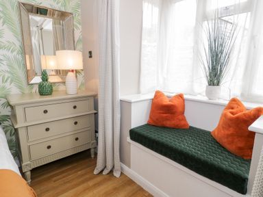 A living room with a window seat and a lamp at Pengwern Bach in Llanrwst