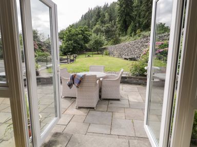 An outdoor seating area with a table and chairs at Pengwern Bach in Llanrwst