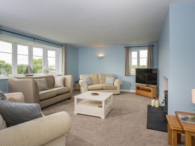 A living room with sofas coffee table and television at Overbrook in Salwarpe near Droitwich Spa