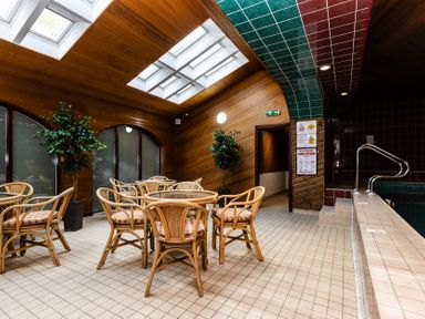 An indoor pool area with chairs and a table at Lupin Cottage Akeld near Wooler
