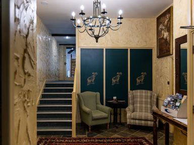 A hallway with stairs and chairs at Lupin Cottage in Akeld near Wooler