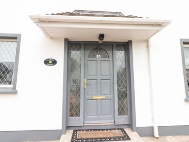 The front entrance door with windows on both sides and a doormat at 17 Clover Hill in Killorglin County Kerry