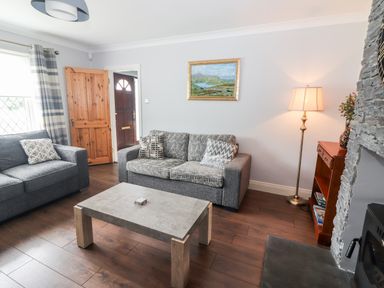 A living room with two sofas a coffee table a floor lamp and a wooden bookshelf at 17 Clover Hill Killorglin County Kerry