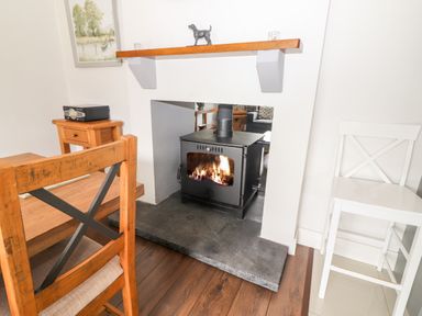 A dining area with a wood burning stove in a white fireplace at 17 Clover Hill in Killorglin County Kerry