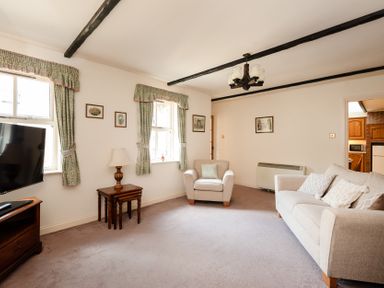 A living room with a television and seating at Bramble Cottage Akeld near Wooler