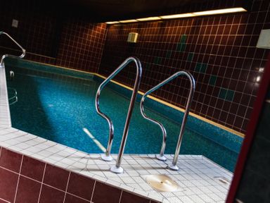 An indoor swimming pool with tiles and handrails at Tile Rouge in Wooler