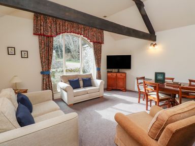 A living room with sofas a television and a dining table at The Columbine in Akeld near Wooler