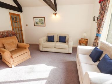 A sitting room with two beige sofas and a brown armchair at The Columbine in Akeld near Wooler