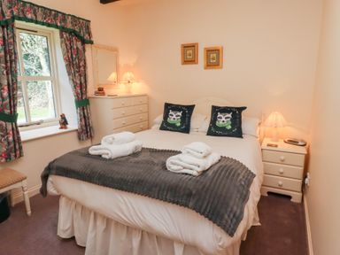 A bedroom with a double bed two bedside tables and a chest of drawers at The Columbine in Akeld near Wooler