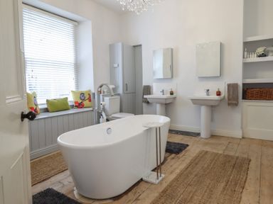 A bathroom with a bathtub and sinks at 5 Porkington Terrace Barmouth
