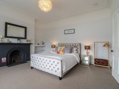 A bedroom with a bed and lamp at 5 Porkington Terrace in Barmouth