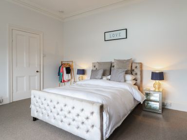 A bedroom with a bed and clothes rack at 5 Porkington Terrace in Barmouth