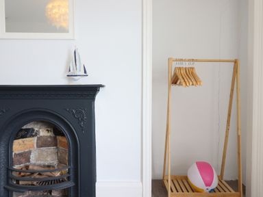 A living room with a fireplace and clothing rack at 5 Porkington Terrace in Barmouth