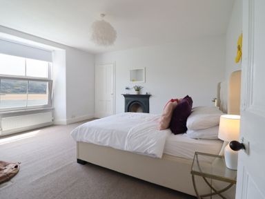 A bedroom with a bed and lamp at 5 Porkington Terrace in Barmouth