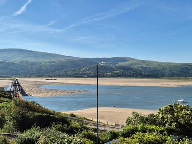 A view of mountains and beach with a bridge at 5 Porkington Terrace Barmouth