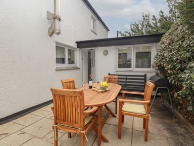An outdoor area with a dining table and chairs at Wrens Nest in Slapton