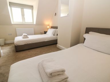 A bedroom with two single beds and folded towels on each bed at Tawny Cottage in Fulbrook near Burford