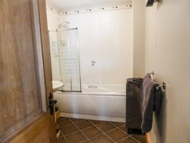 A bathroom with a bathtub shower sink and towel rack at Apartment One in Duncannon County Wexford