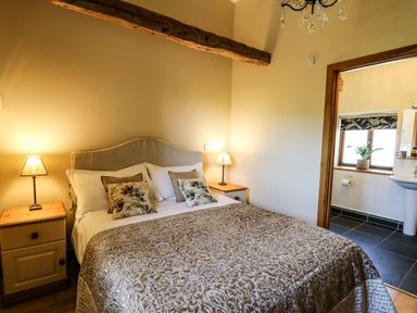 A bedroom with a double bed and bedside tables with lamps at Golwg Las Pumsaint near Lampeter