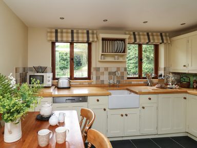 A kitchen with wooden countertops mugs and a teapot on a wooden table at Nant Glas in Pumpsaint near Lampeter
