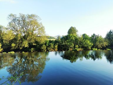 A river with trees along the bank and hills in the background at Kooky Cottage in Brecon