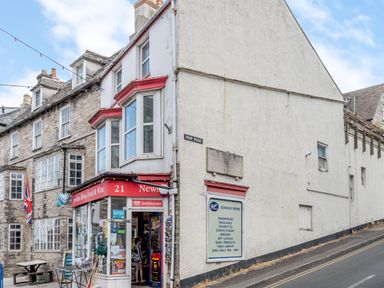 A corner shop named Jenkins News with windows and signs on a street called Park Road