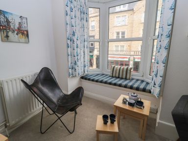 A living room with a window seat and tea set at Still Waters in Swanage