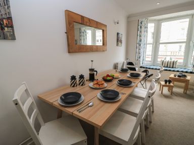 A dining room with a table set for a meal at Still Waters in Swanage