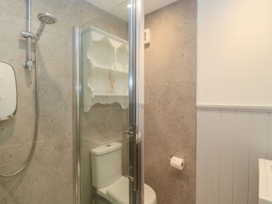 A bathroom with a shower and toilet at Still Waters in Swanage