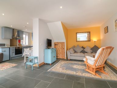 An open living area with a kitchen diner on the left and a sitting area on the right at Hill Coach House in Watchet
