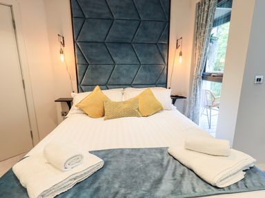 A bedroom with a double bed and pillows and towels on the bed at Rivers Edge in Newby Bridge