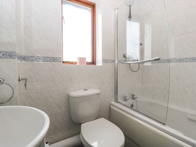 A bathroom with a toilet sink bathtub shower and a window at 16 Mythern Meadow Bradford-On-Avon
