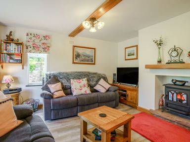 A living room with sofas a wooden coffee table a television and a fireplace at Kavieng Glangrwyney near Gilwern