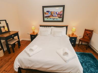 A bedroom with a bed and lamps on bedside tables at Brynawel in Llangynin near Llanboidy