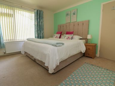 A bedroom with a bed and bedside table with a lamp at Rathillet Feock near Truro
