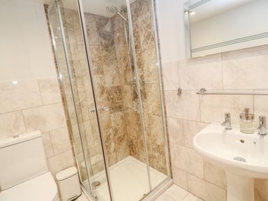 A bathroom with a tiled walk-in shower toilet sink and a mirror at 16 Arwenack Street in Falmouth