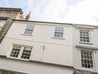 A row of white buildings with windows and a chimney at 16 Arwenack Street in Falmouth