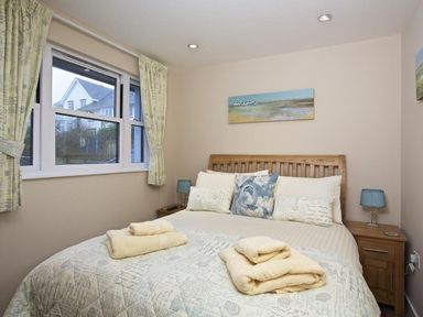 A bedroom with a bed with folded towels and pillows beside a window at Crowthers in Dartmouth