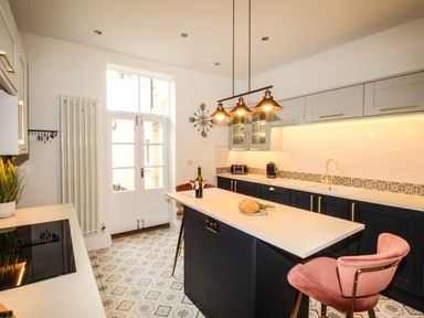 A kitchen with a central island stool and patterned floor tiles at Seaside House in Weymouth