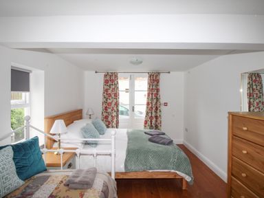 A bedroom with a double bed and a single bed with pillows and folded towels at Seaside House in Weymouth
