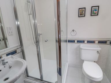 A bathroom with a shower enclosure sink and toilet at Ridley Lodge in West Thirston felton