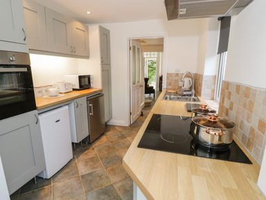 A kitchen with wooden countertops stove pots sink and cabinets at Florence Villas in Worcester