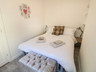 A bedroom with a double bed and folded towels at Florence Villas in Worcester