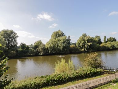 A river with a person rowing a boat and trees on both banks at Florence Villas in Worcester