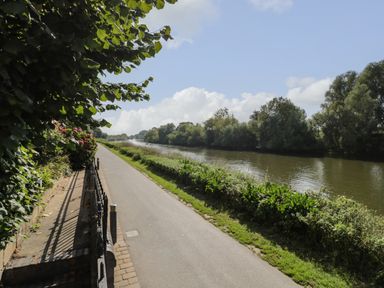 A paved pathway beside a river with greenery and trees at Florence Villas in Worcester
