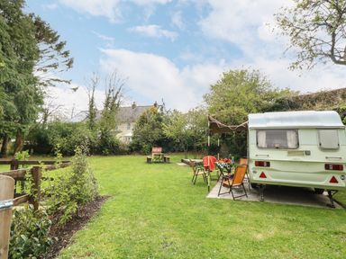 A garden with a caravan and outdoor seating area at Norden House in Maiden Newton
