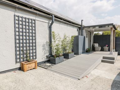 An outdoor patio area with wooden planters plants seating and a ramp at Westfields in Kennards House near Launceston