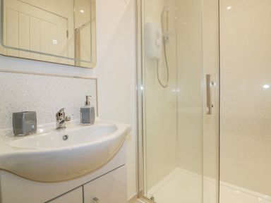 A bathroom with a sink and a glass-enclosed shower at The Cornstore in Helland near Bodmin