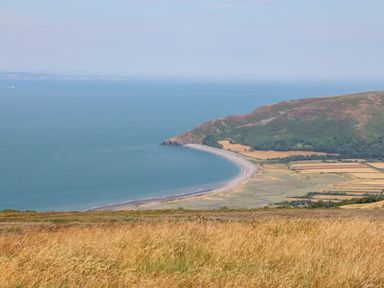A coastal landscape with a curved beach hills and fields at The Cadeleigh in Cadeleigh near Tiverton