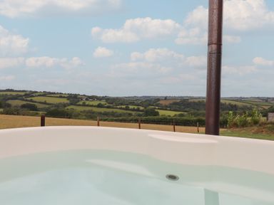 A hot tub overlooking a rural landscape at The Cadeleigh near Tiverton